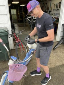 Erik Leamon adds a sticker to a newly refurbished bicycle